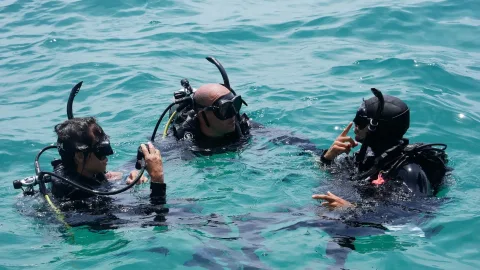 Instructor briefing divers at the surface