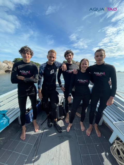 Group of divers in AquaTao wetsuits on the boat