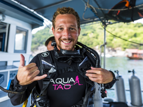 AquaTao instructor smiling in wetsuit on the boat