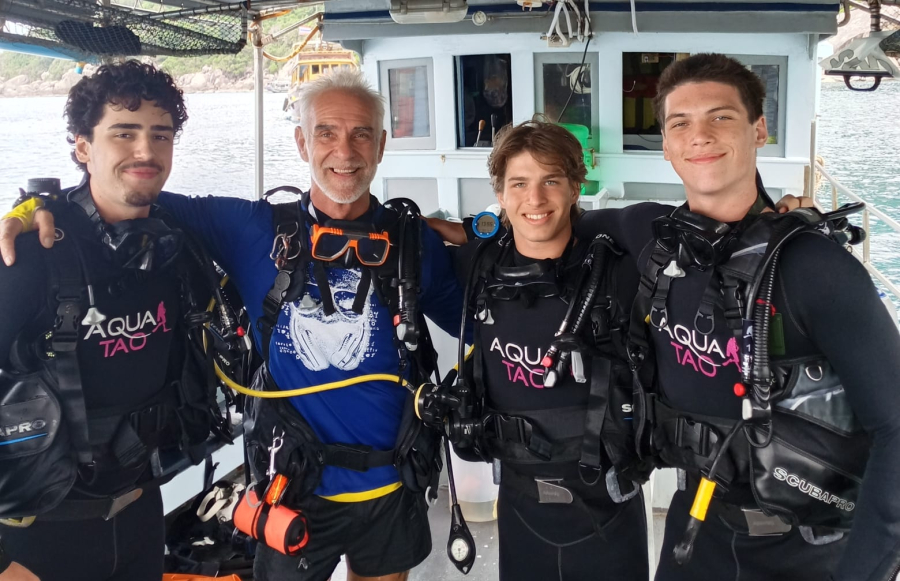 Instructor with a group of young divers on the boat