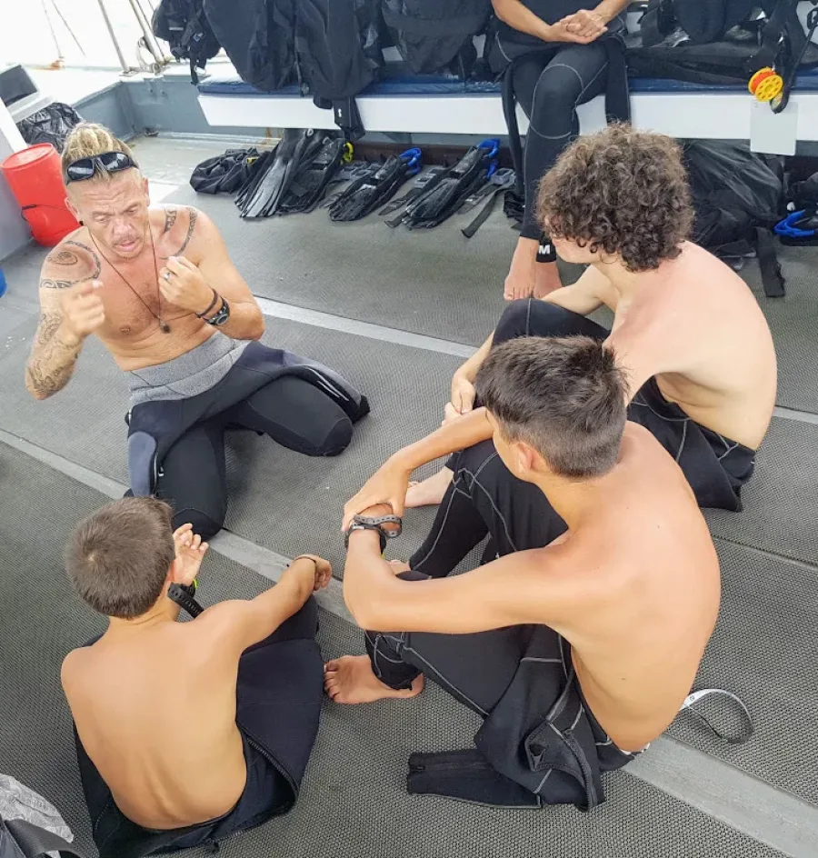 Instructor debriefing a group seated on the boat